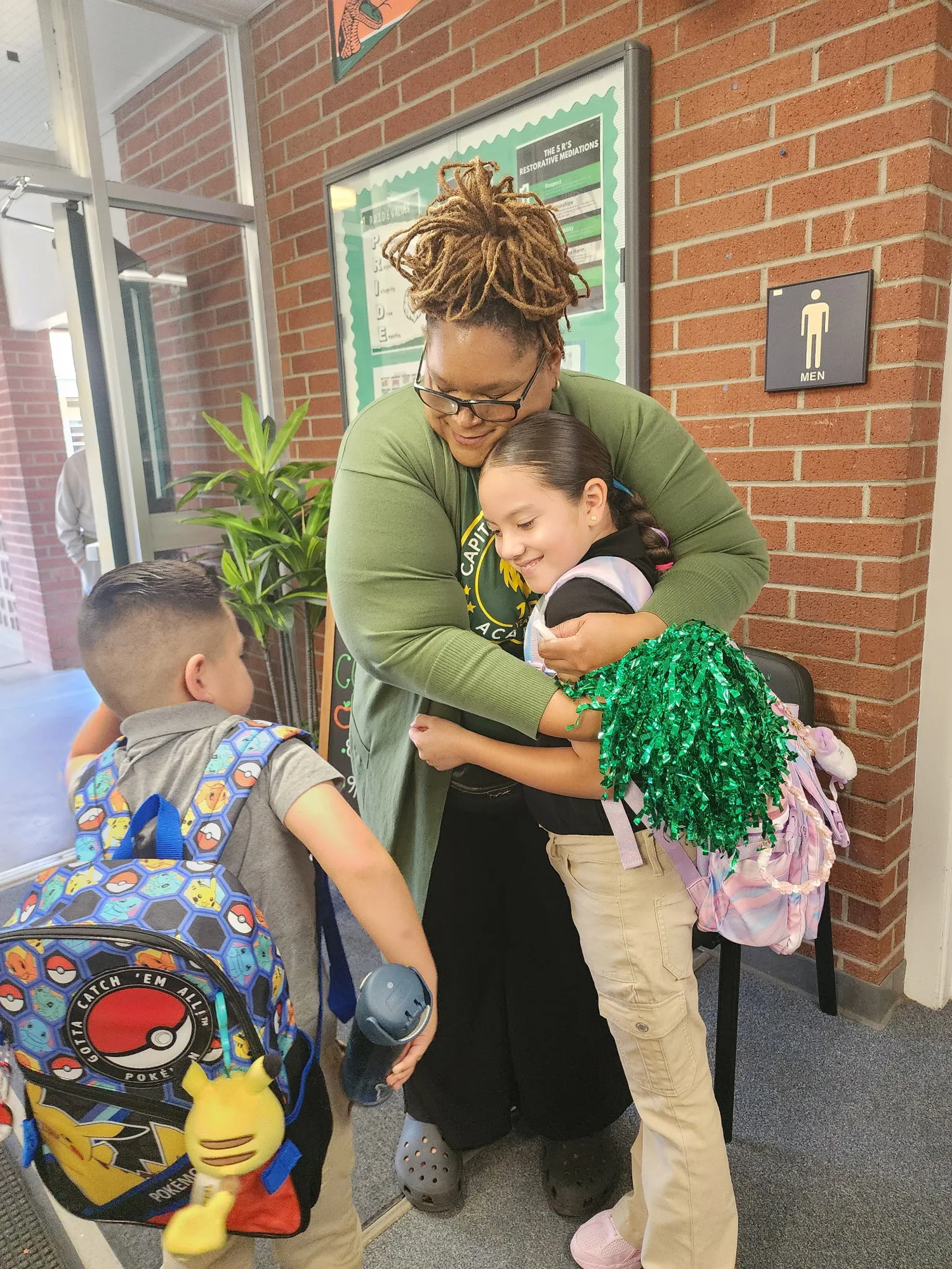 The principal welcoming a student with a warm hug